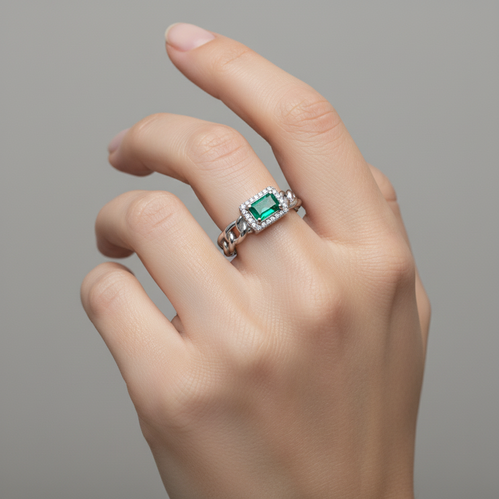 Anello con smeraldo indossato su mano elegante
