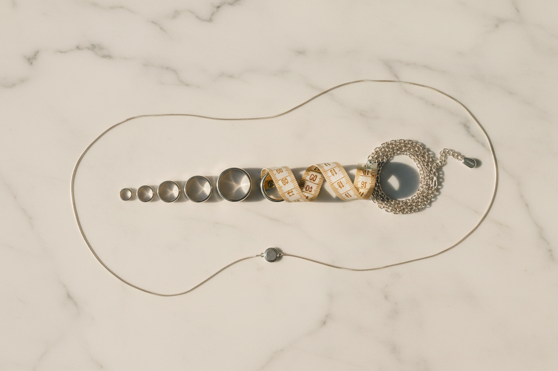 Anelli, bracciale e collana in argento 925 con metro da sarto dorato su marmo bianco — Guida alle taglie Gabriel Milano