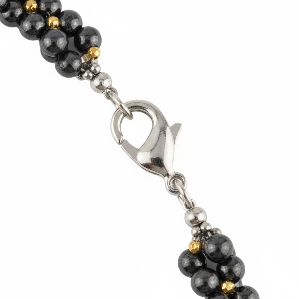 Primo piano chiusura collana ematite grigia e oro